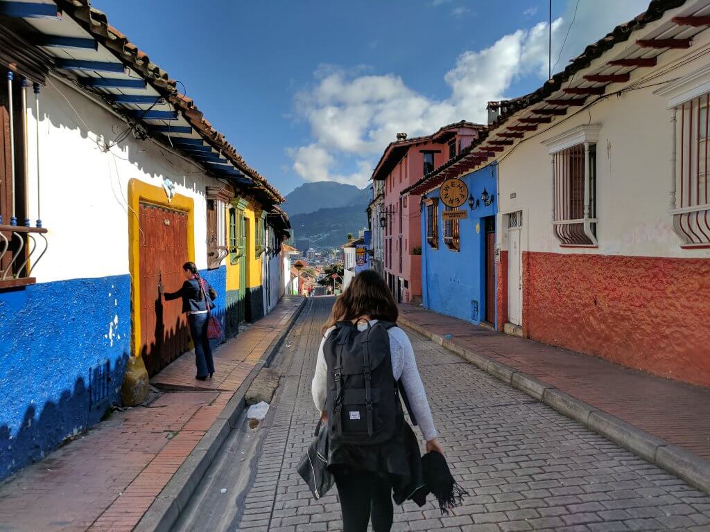 woman walking through colorful town in South America