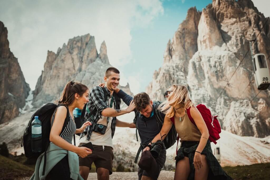 friends laughing while traveling and wearing backpacks