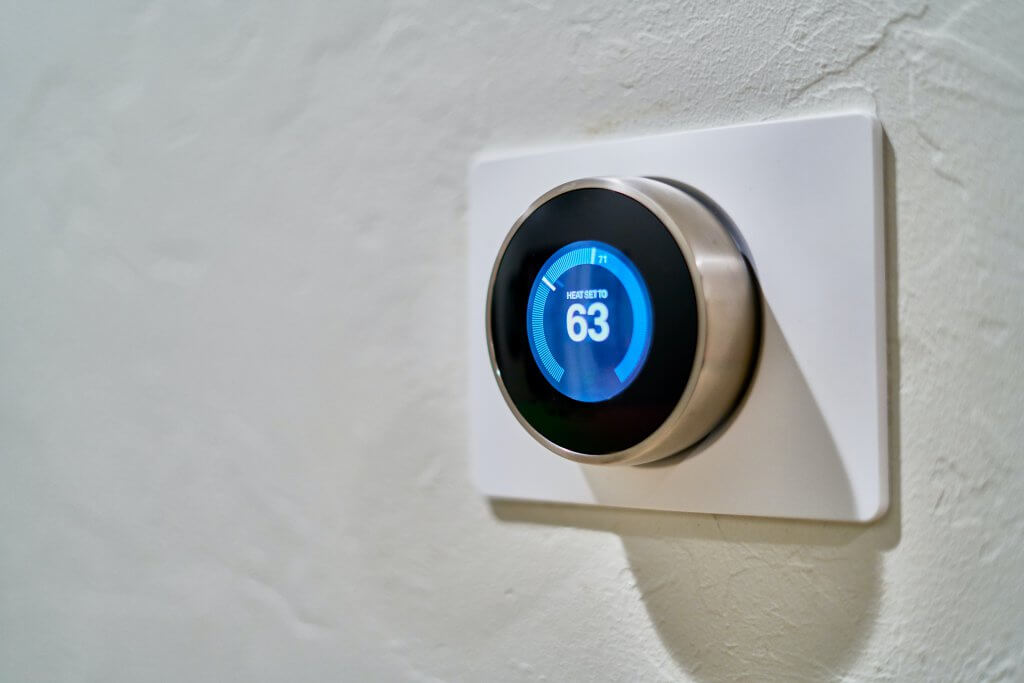 smart thermostat set to 63º on white wall