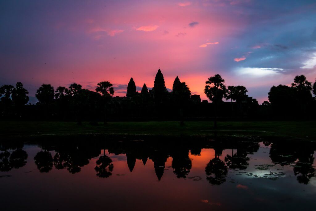 Pink sky sunrise behind Angkor Wat temple complex in Siem Reap, Cambodia