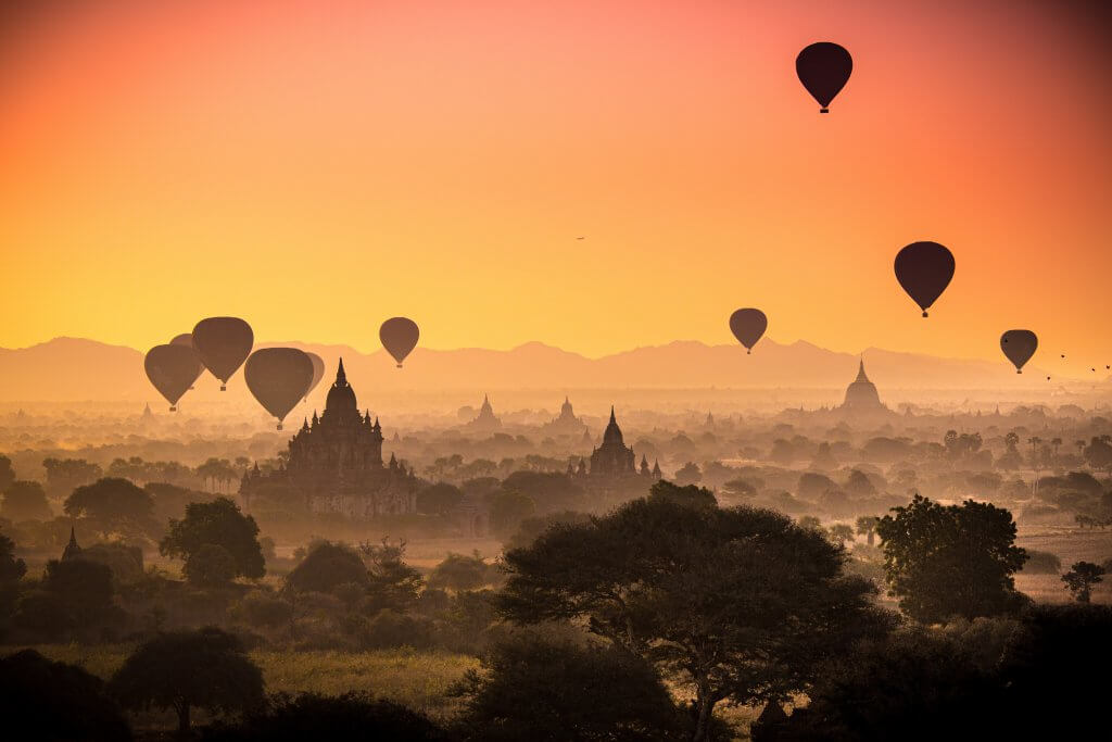 silhouettes of hot air balloons flying over temples in Bagan, Myanmar