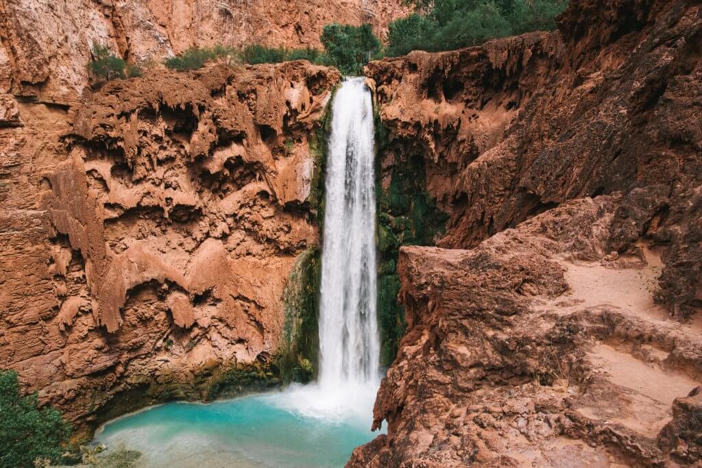 red rock havasu canyon waterfall cascading into a pool of water below
