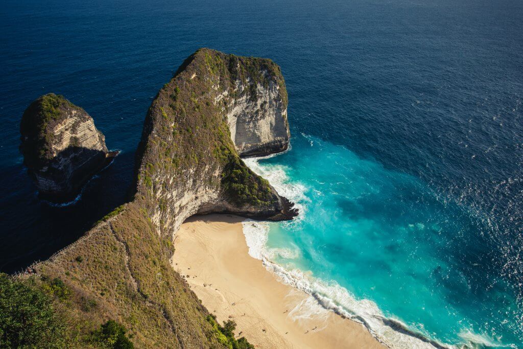 aerial view of a shoreline rock form that resembles the open mouth of a Dinosaur on Nusa Penida, Bali