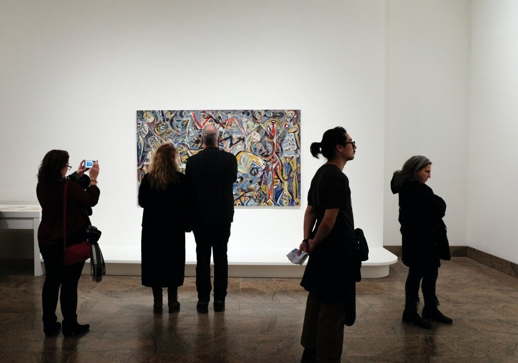 people in an art gallery with white walls and one colorful painting