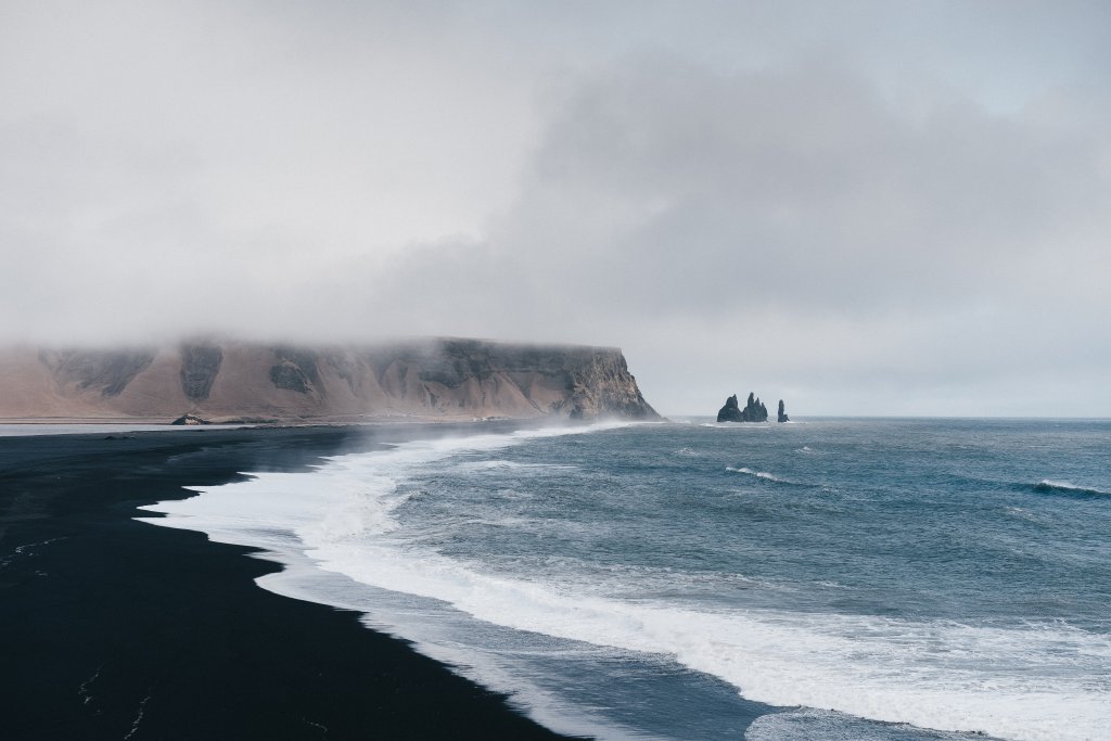 black sand beach shoreline on a foggy day