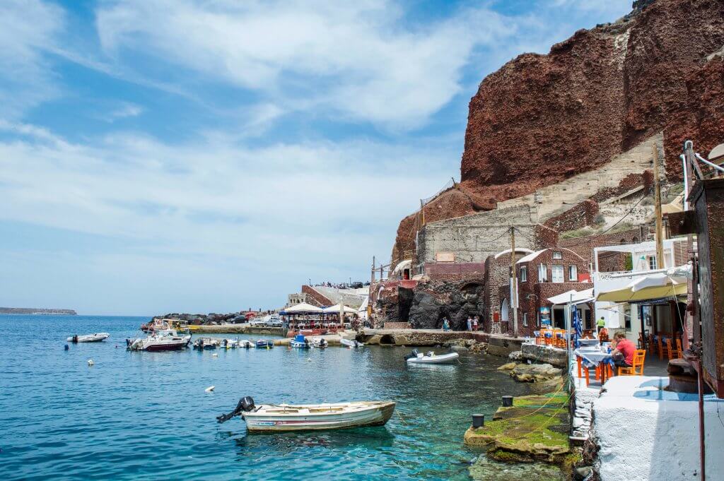 Restaurants and boats docked along Amoudi Bay in Santorini