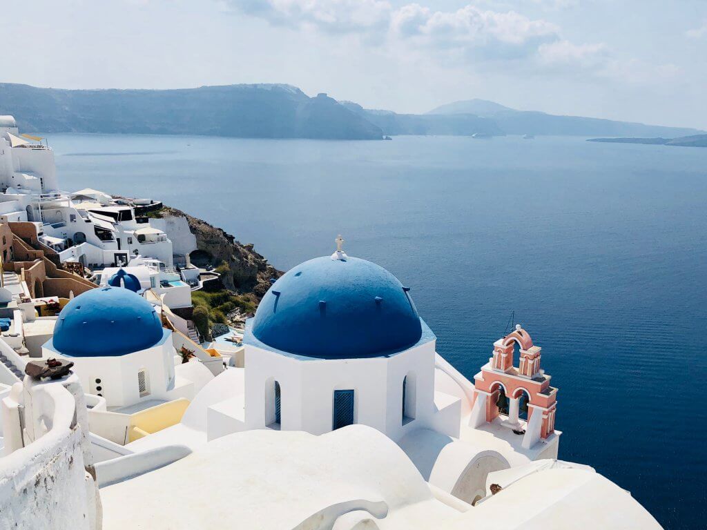 blue domed homes of oia with ocean in the background