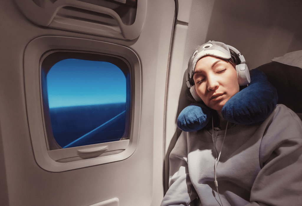 woman sleeping in the window seat for article on what is a red eye flight | dollar flight club