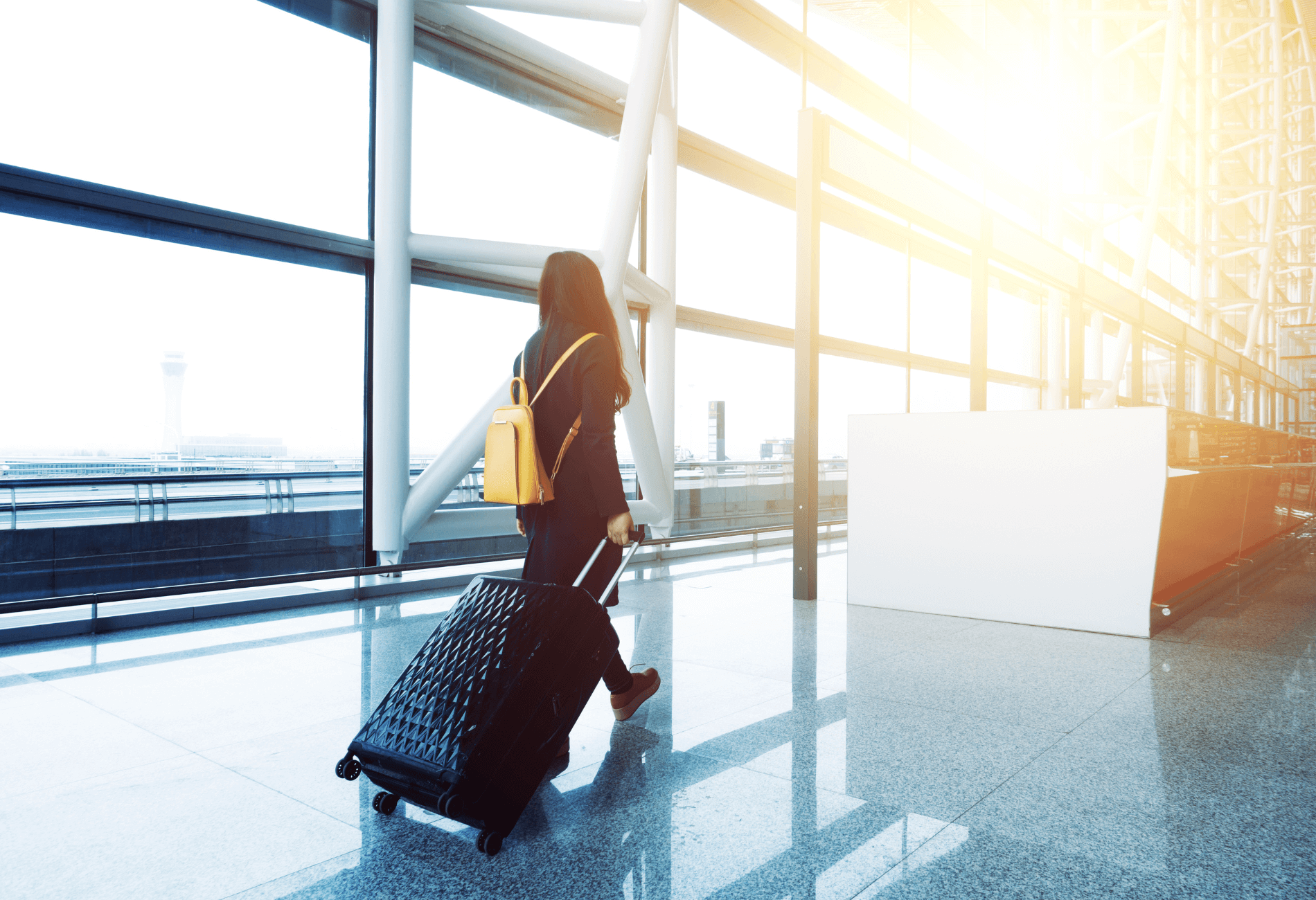 woman with luggage at airport | dollar flight club