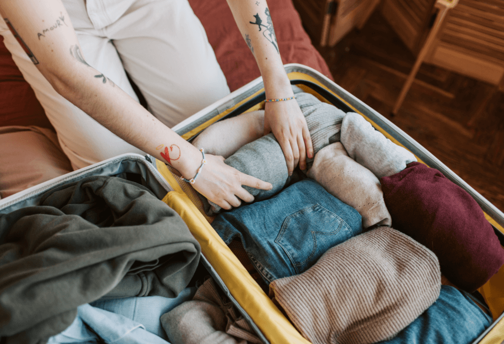 person learning how to pack a suitcase