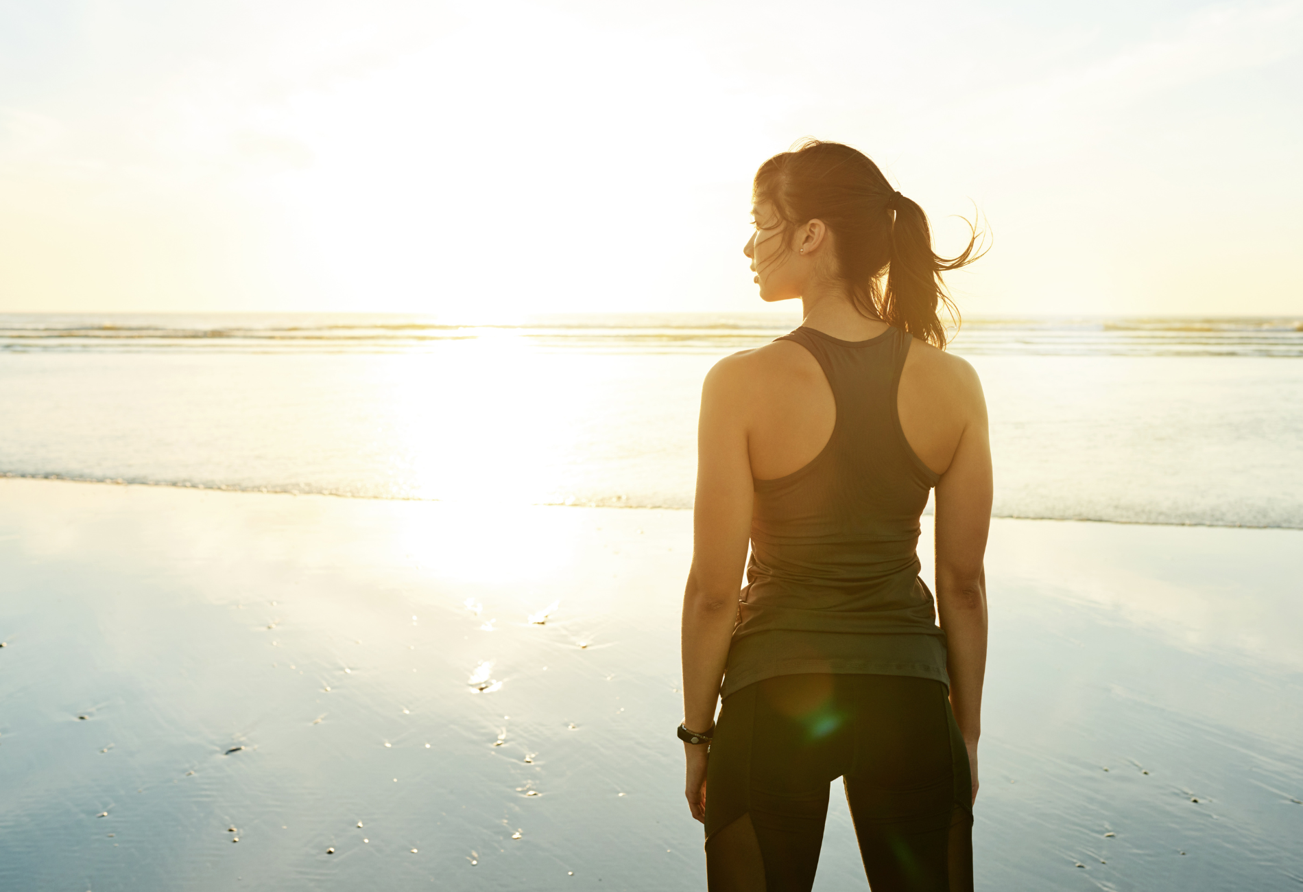 woman on beach going for a run | what to pack for maintaining a healthy lifestyle while traveling | travel workout equipment | travel wellness products | Dollar Flight Club