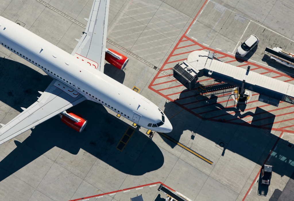 overhead view of plane | person with passport and airline ticket at airport