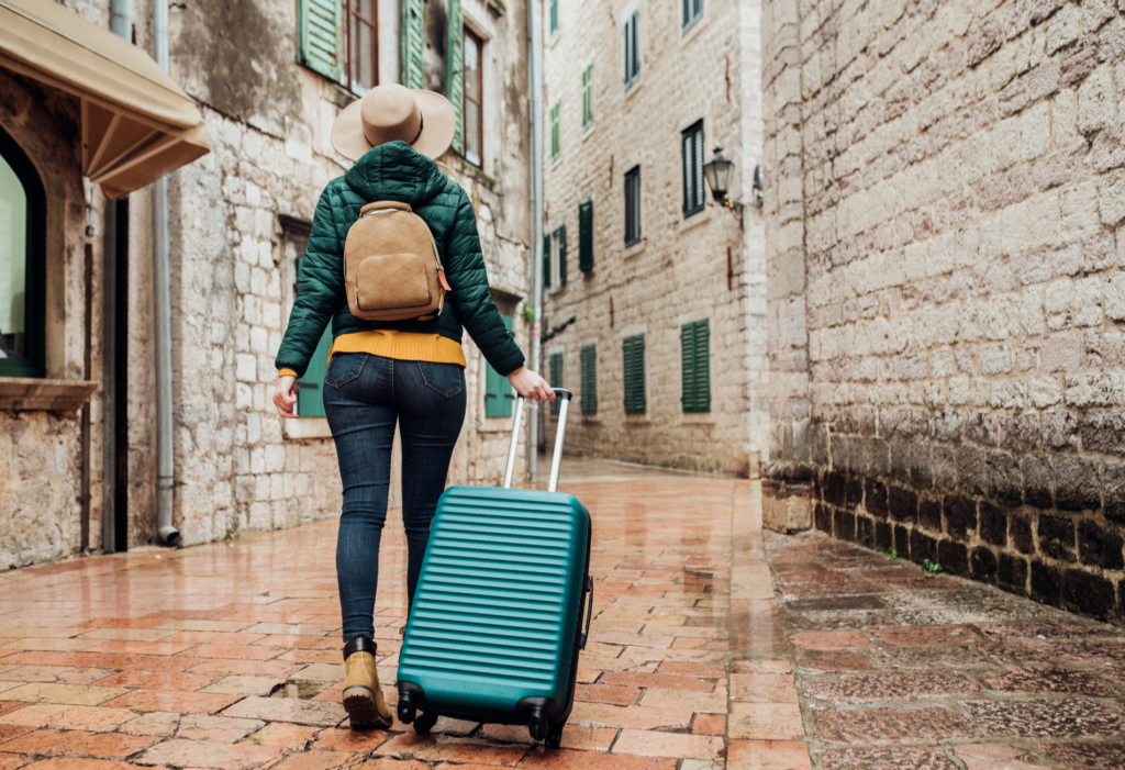 mystery travel, woman walking in Europe with luggage